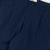 Navy blue pleated pants with a visible brand label on a white background