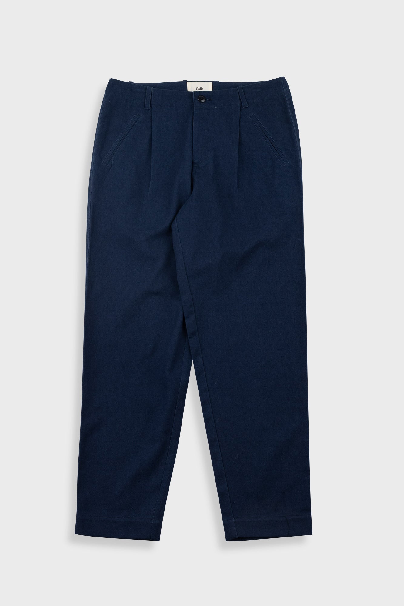 Navy blue pleated pants with a visible brand label on a white background