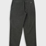 Dark green pleated pants with a close-up on the waistband and pleats.