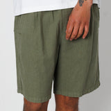Person wearing olive green shorts on a plain background