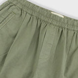 Close-up of green pants with an elastic waistband on a light gray background