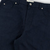 Close-up of black pants with a white background