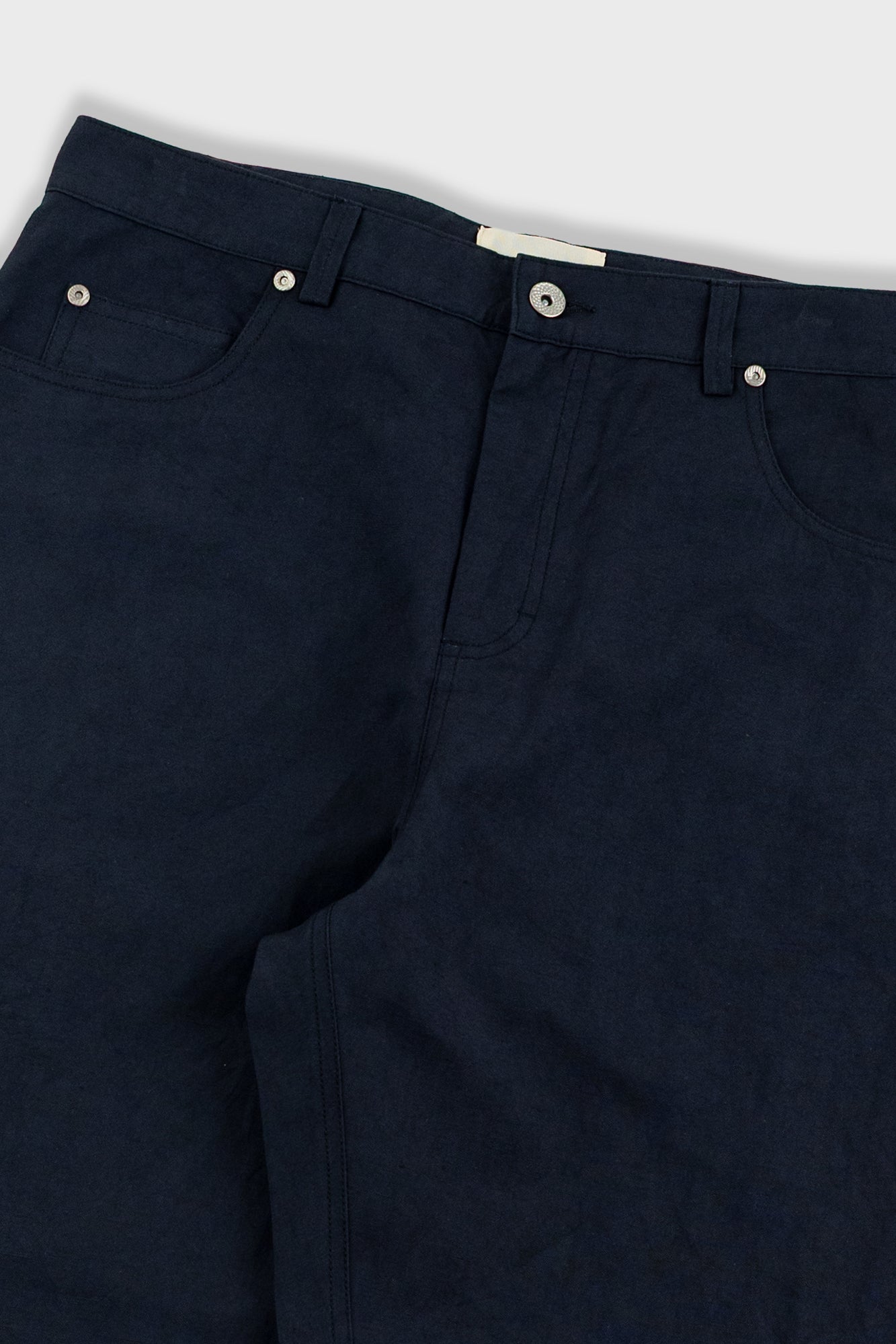 Close-up of black pants with a white background