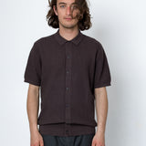 Man wearing a dark brown short-sleeve shirt against a white background