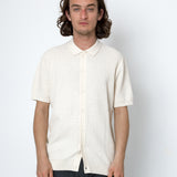 Man wearing a white short-sleeve shirt against a white background