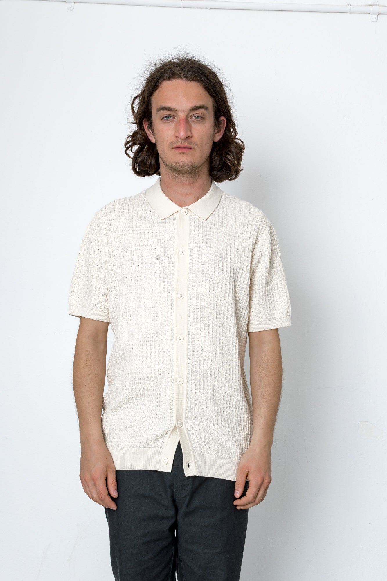 Man wearing a white short-sleeve shirt against a white background
