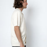 Man wearing a white textured shirt against a white background
