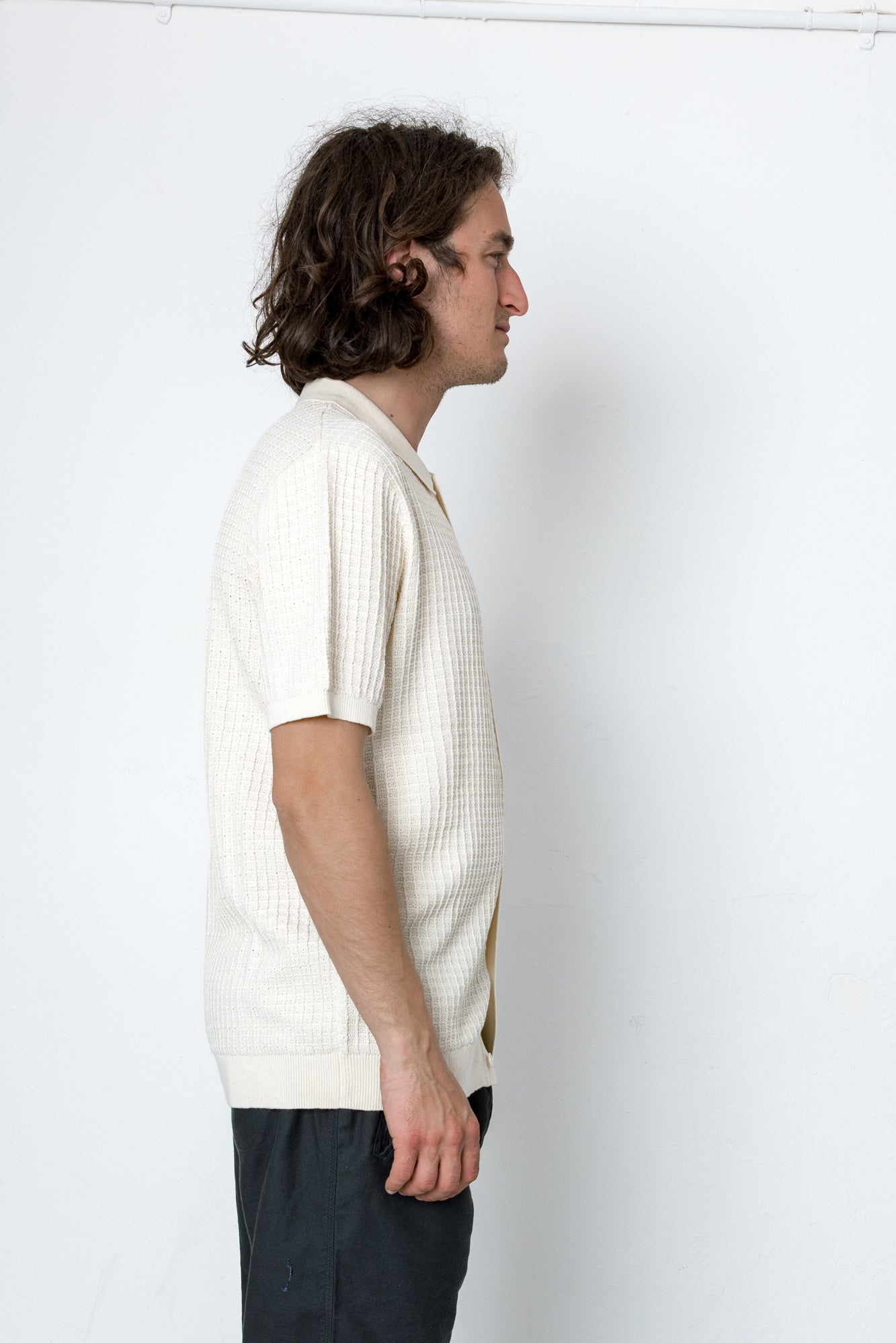 Man wearing a white textured shirt against a white background