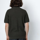 Person wearing a dark green textured shirt against a white background