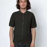 Man wearing a black textured shirt against a white background