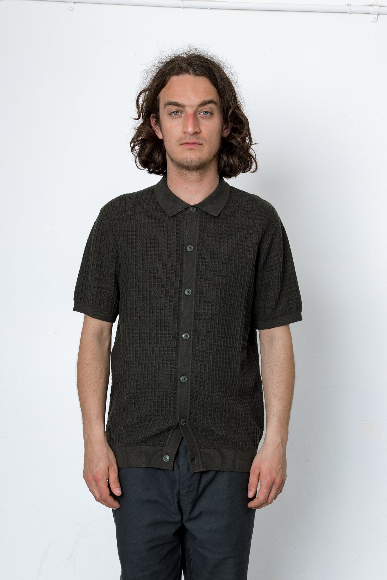 Man wearing a black textured shirt against a white background
