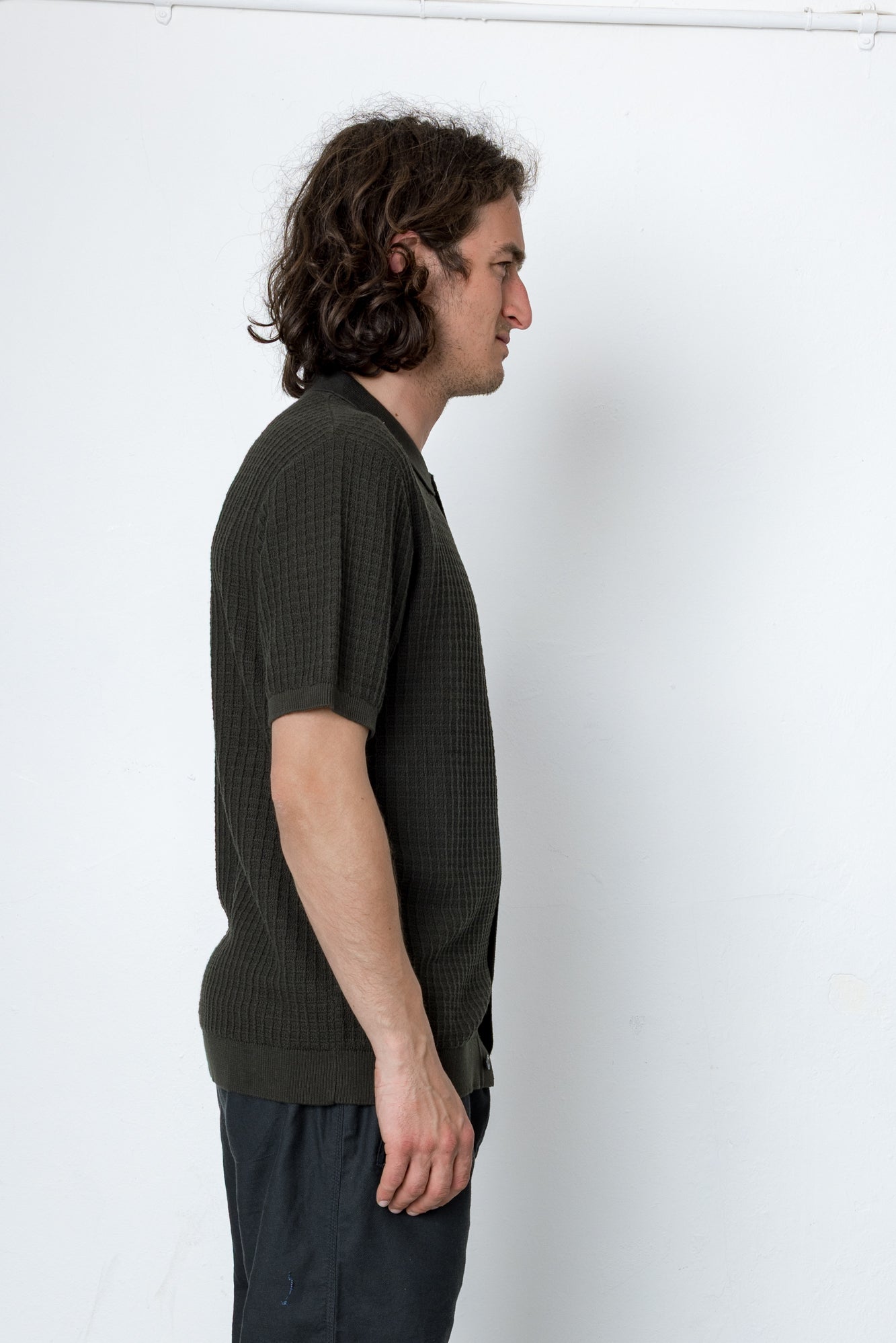Man wearing a dark green textured shirt against a white background
