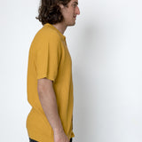 Man wearing a yellow shirt against a white background
