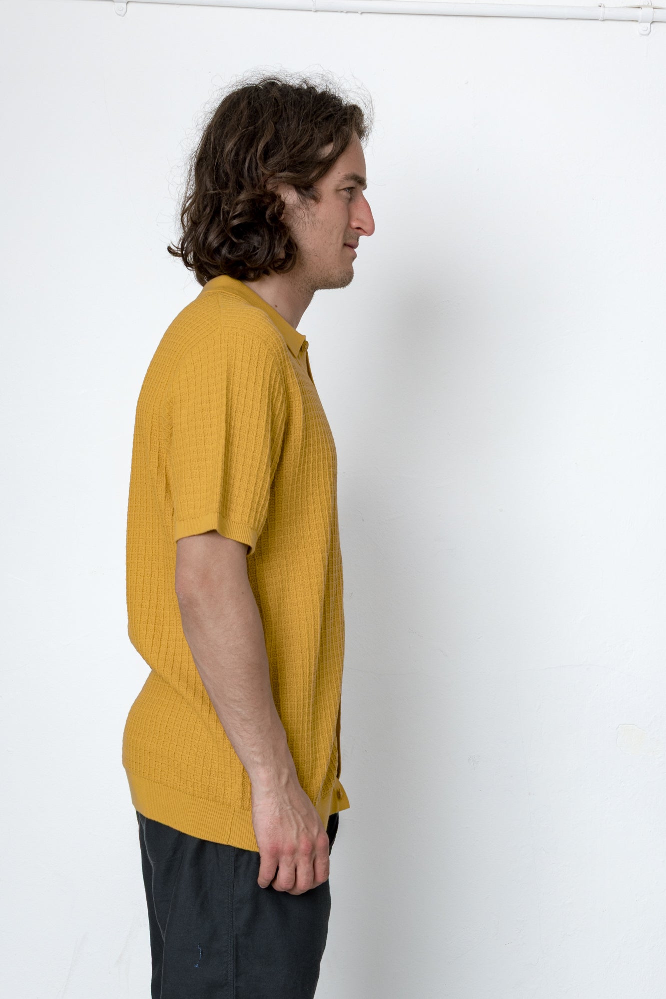 Man wearing a yellow shirt against a white background