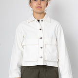 Person wearing a white jacket on a plain background