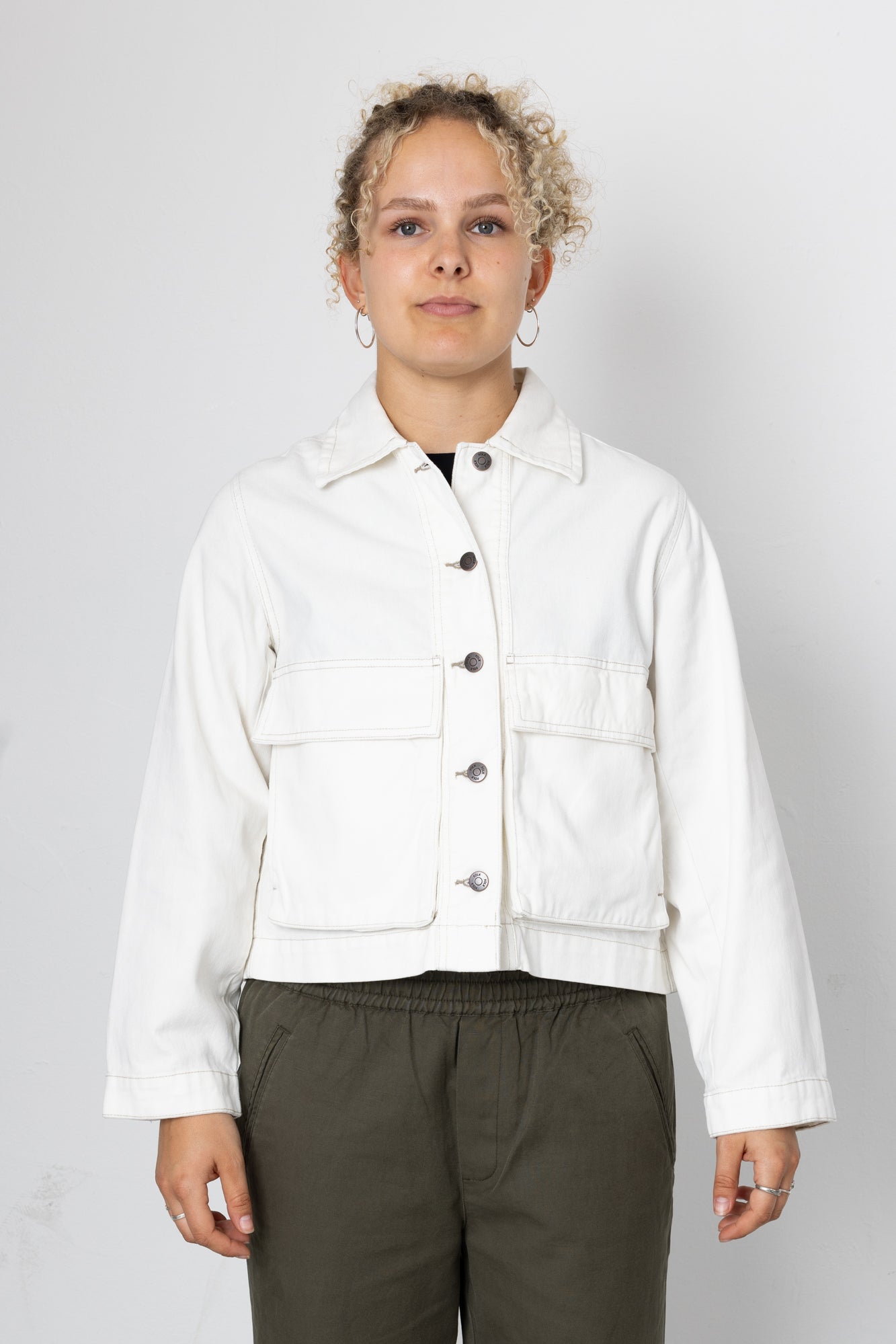 Person wearing a white jacket on a plain background