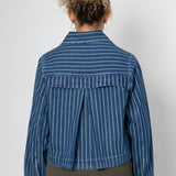 Person wearing a blue striped shirt against a white background