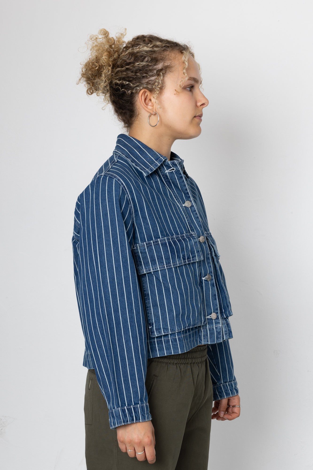 Person wearing a blue striped jacket on a white background