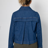 Person wearing a blue denim jacket on a white background