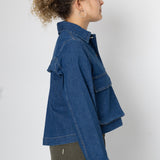 Person wearing a blue denim jacket on a white background