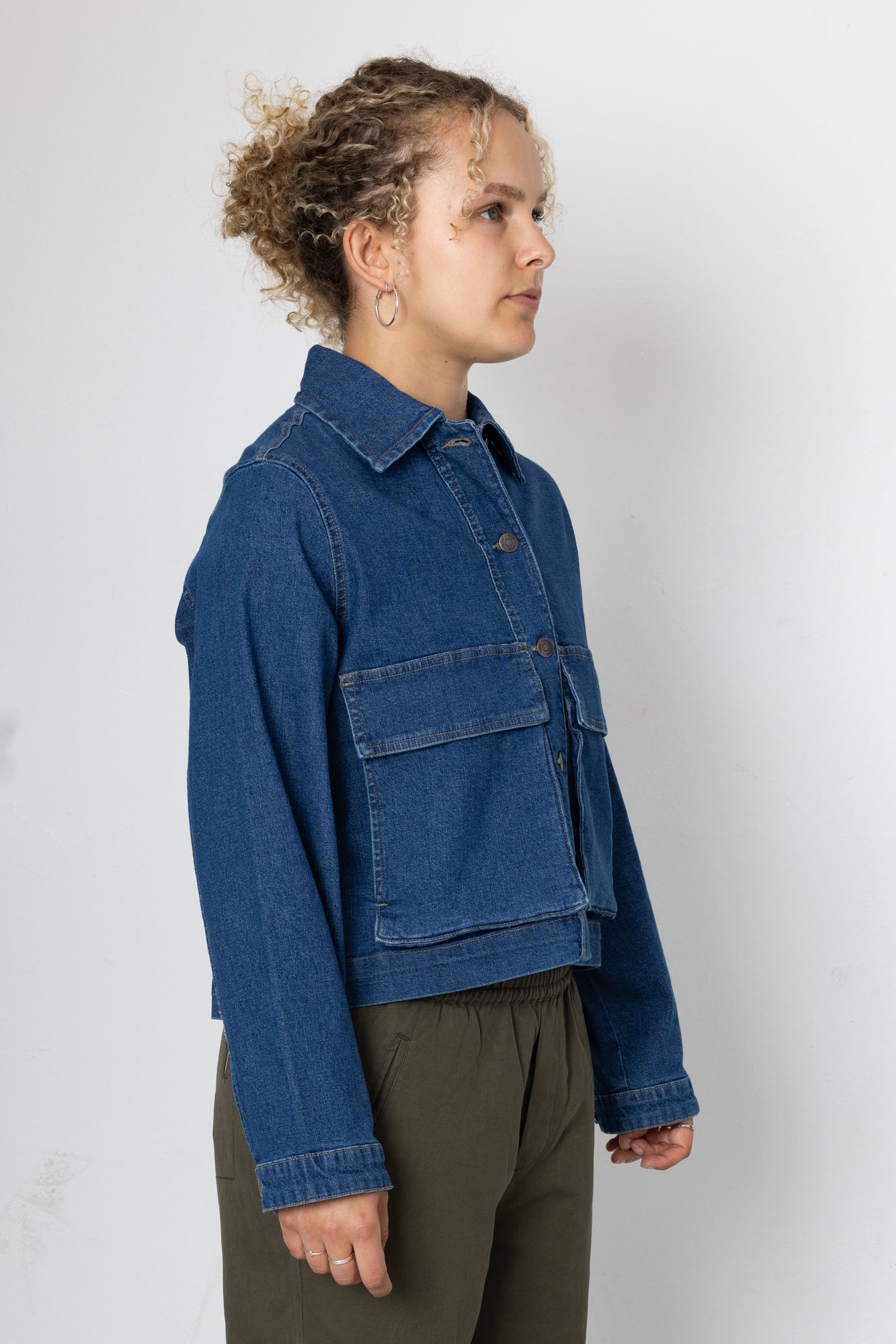 Person wearing a blue denim jacket against a plain background