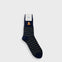 A single navy blue sock with dark green horizontal stripes and a small orange and white graphic near the cuff, shown on a light gray background.