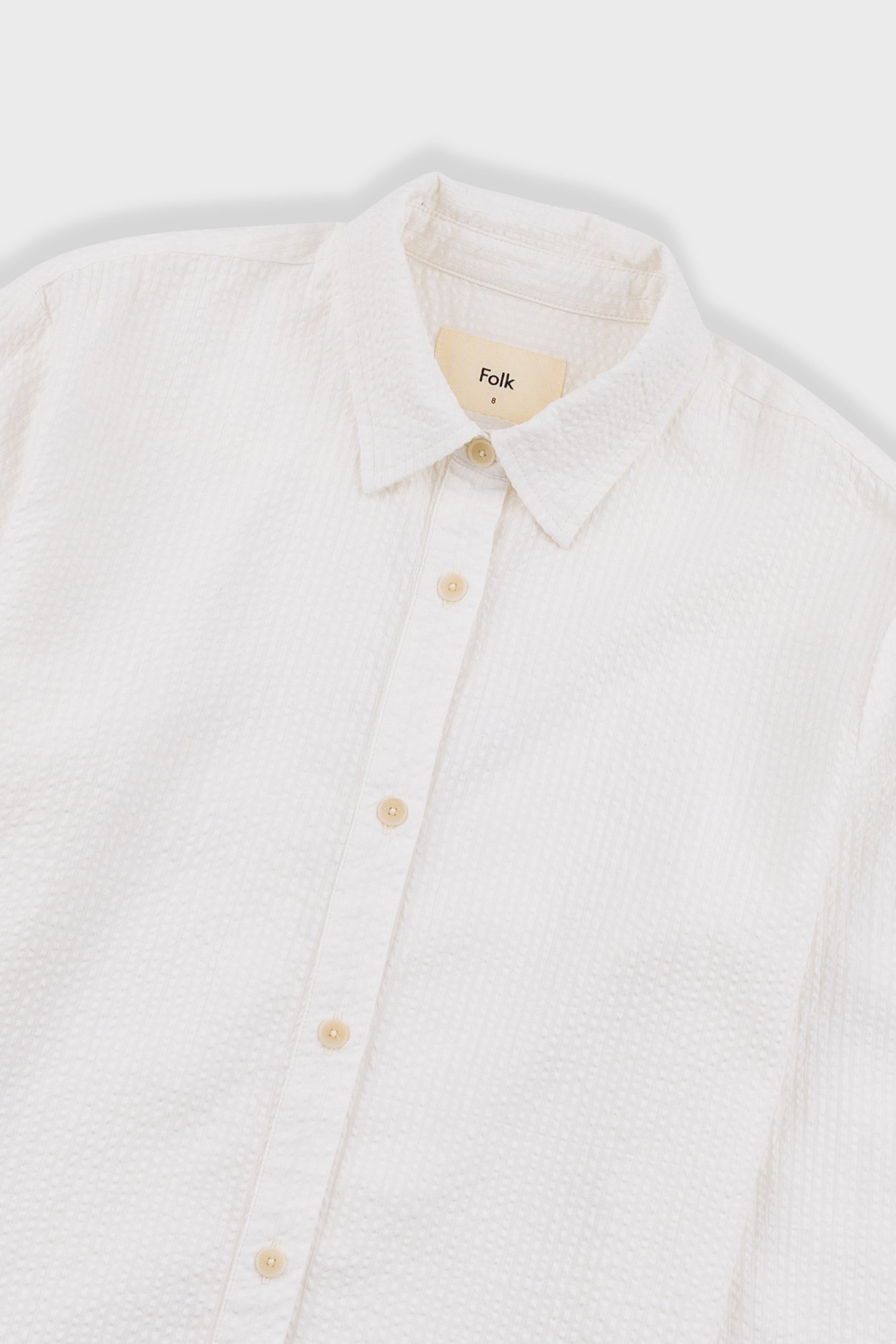 White button-up shirt with collar on a light gray background