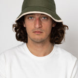 Man wearing a green bucket hat against a white background