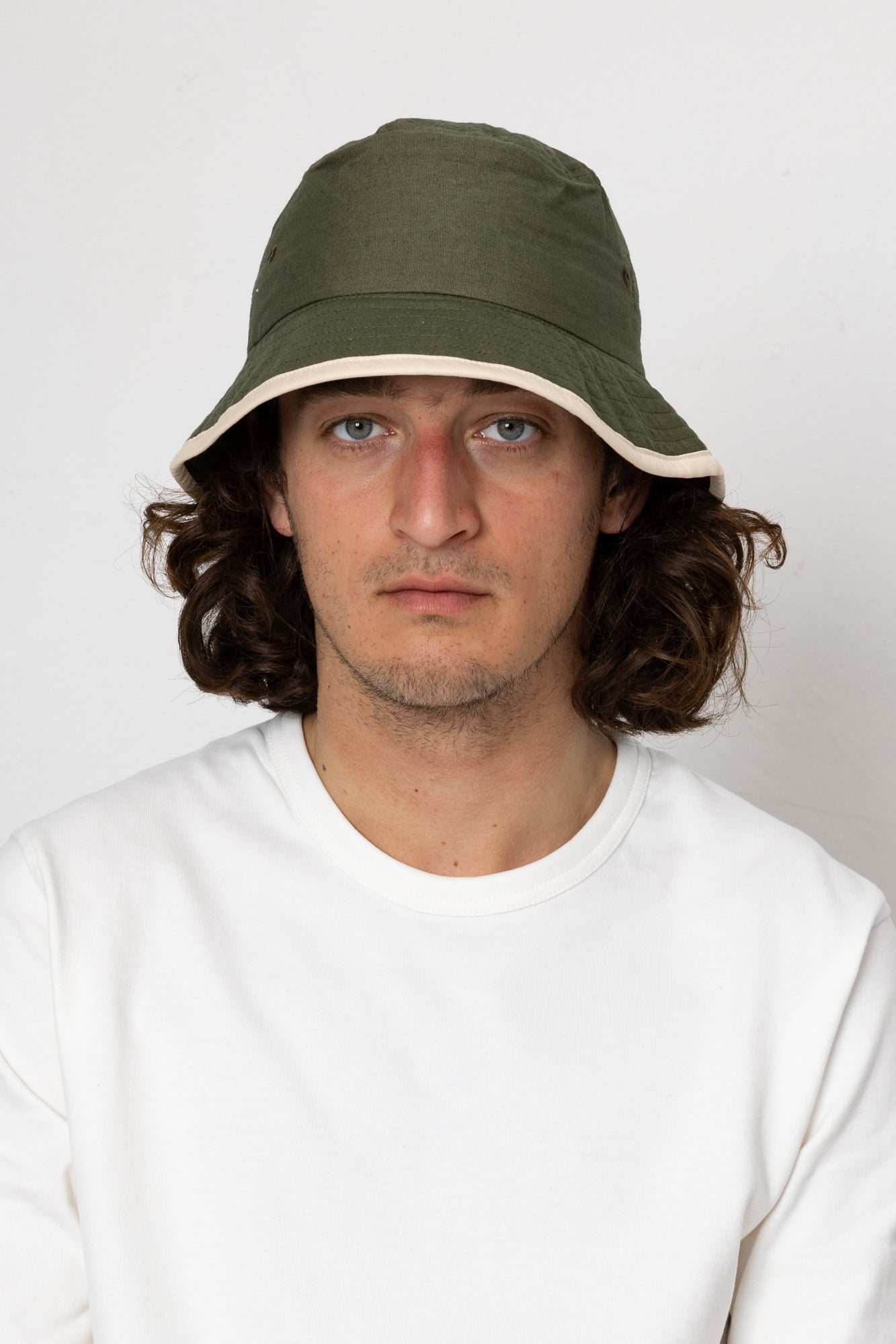Man wearing a green bucket hat against a white background