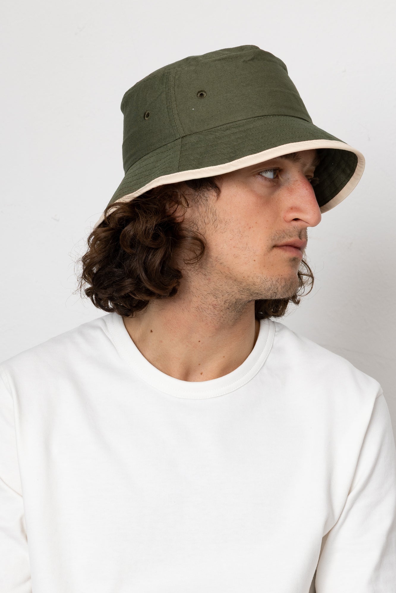 Person wearing a green bucket hat against a white background