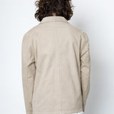 Person wearing a beige jacket with a plain white background
