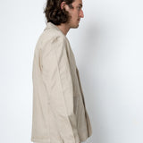 Man wearing a beige jacket against a white background