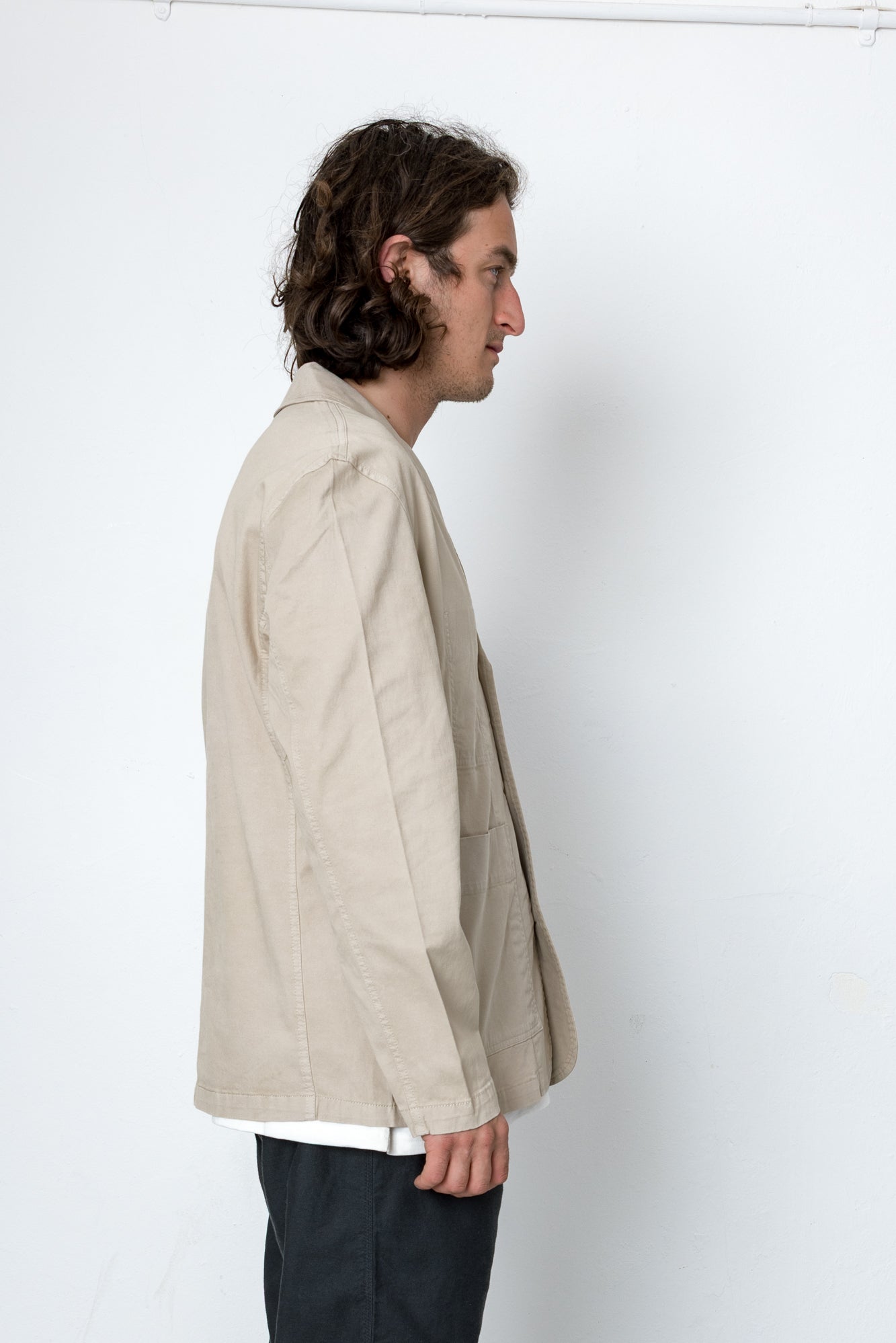 Man wearing a beige jacket against a white background
