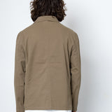 Person wearing a beige jacket against a white background