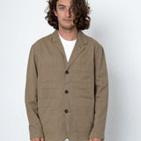 Man wearing a beige jacket over a white shirt on a white background