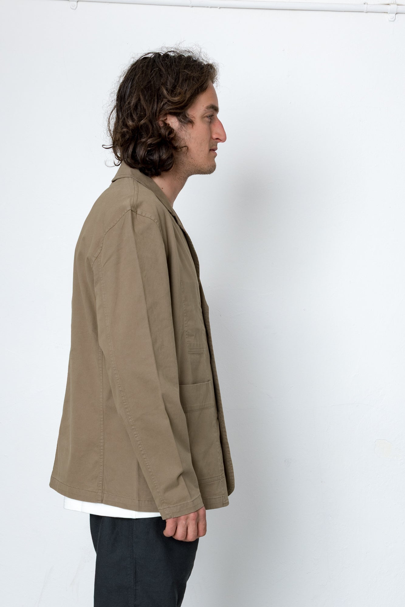 Person wearing a beige jacket against a white background