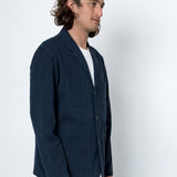 Man wearing a navy blue jacket against a white background