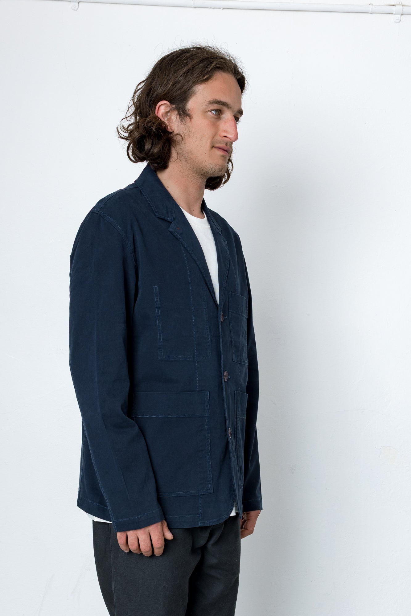 Man wearing a navy blue jacket against a white background