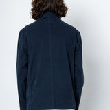 Person wearing a navy blue jacket against a white background