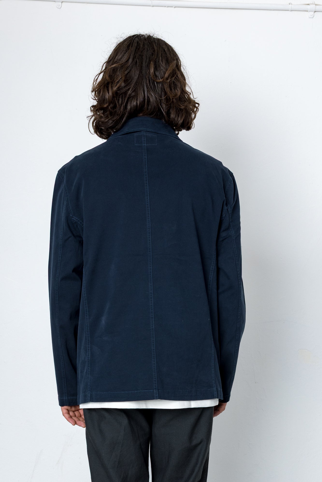 Person wearing a navy blue jacket against a white background