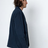 Man wearing a navy blue jacket against a white background