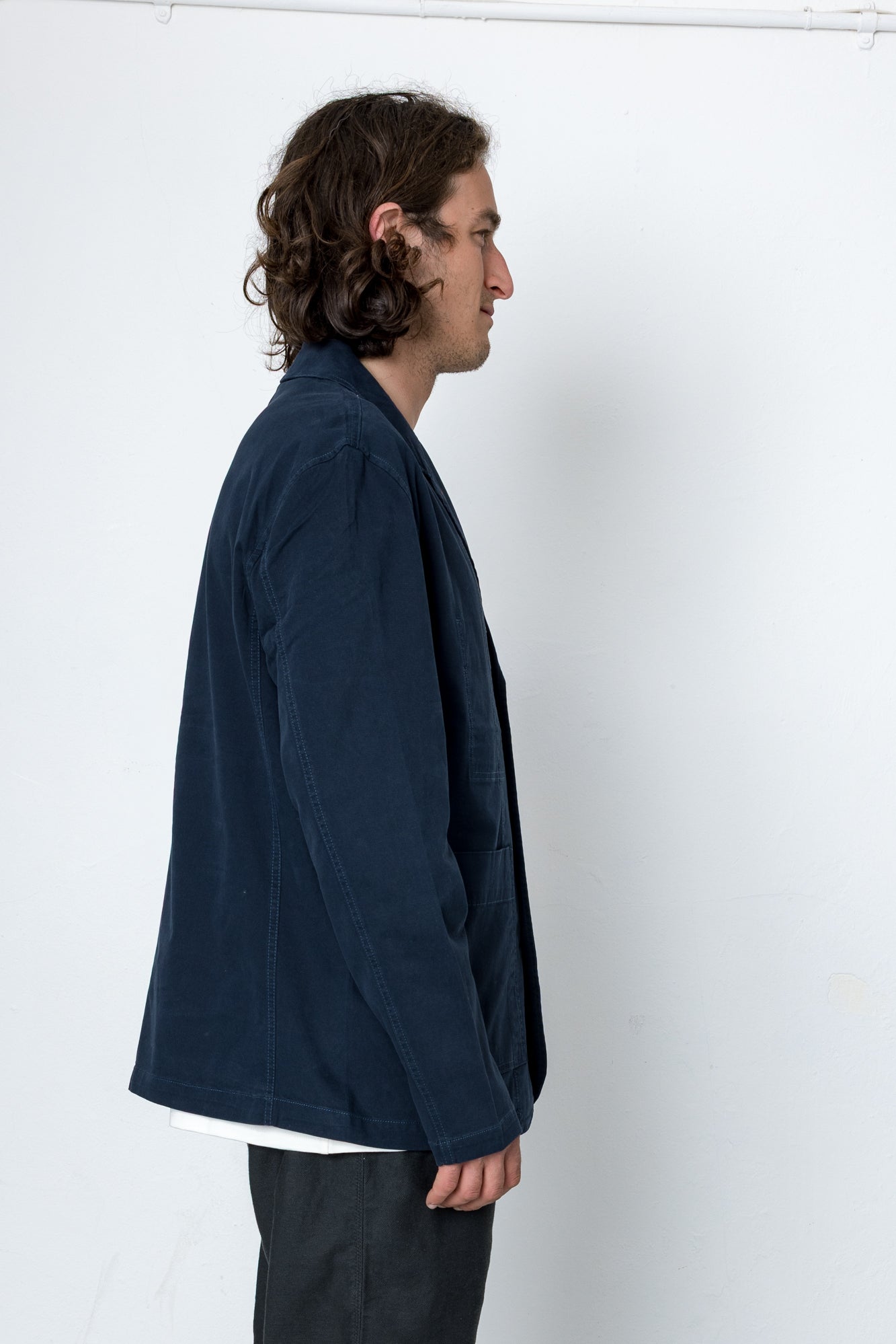 Man wearing a navy blue jacket against a white background