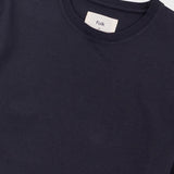 Close-up of a dark navy crewneck t-shirt with a white neck label reading 'Folk'.