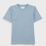 Close-up of a light blue crewneck t-shirt with a white neck label reading 'Folk'.