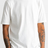 A man wearing a plain white short-sleeve crewneck t-shirt, shown from the neck down against a light gray background.