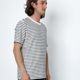 Man wearing a black and white striped t-shirt against a white background