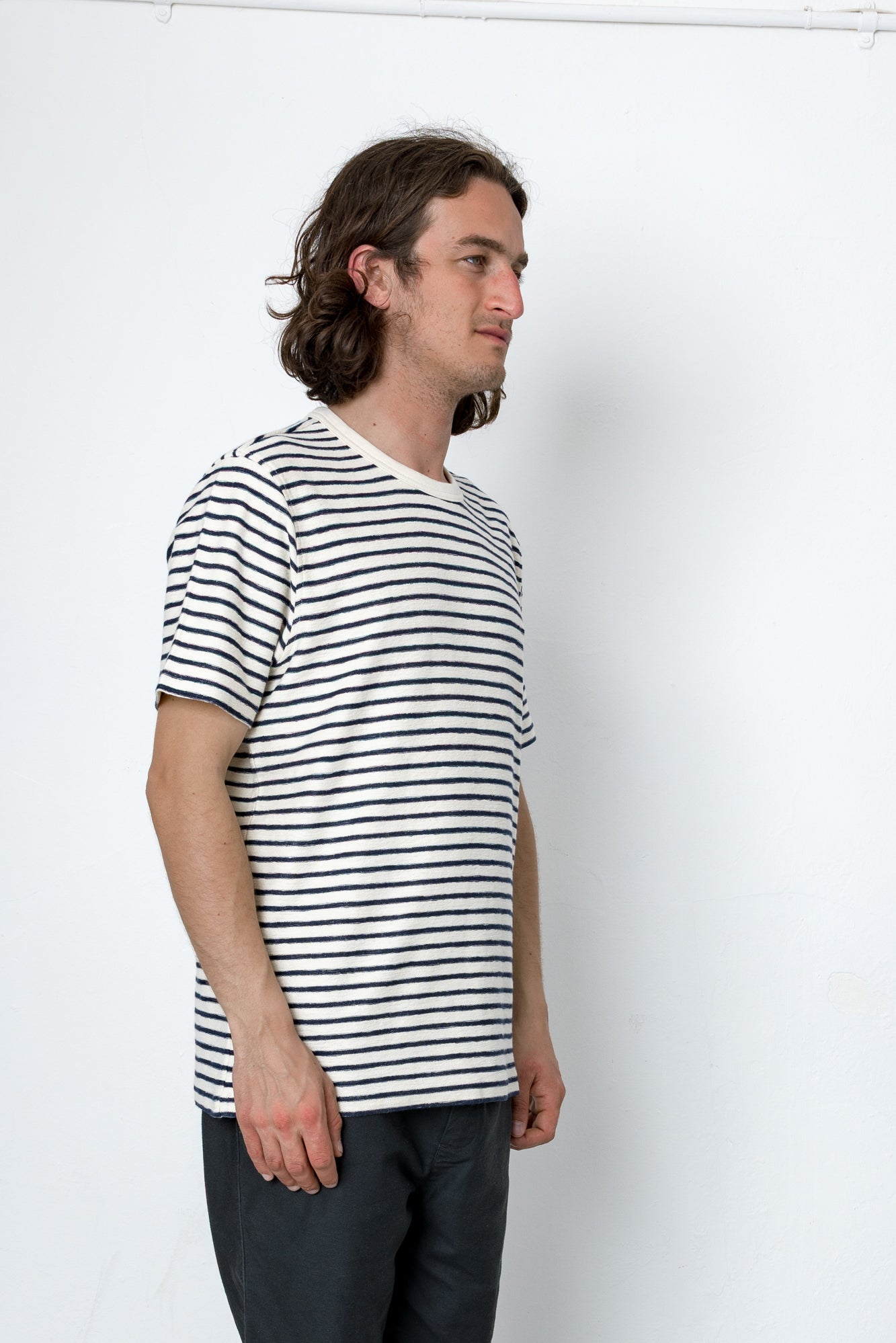 Man wearing a black and white striped t-shirt against a white background