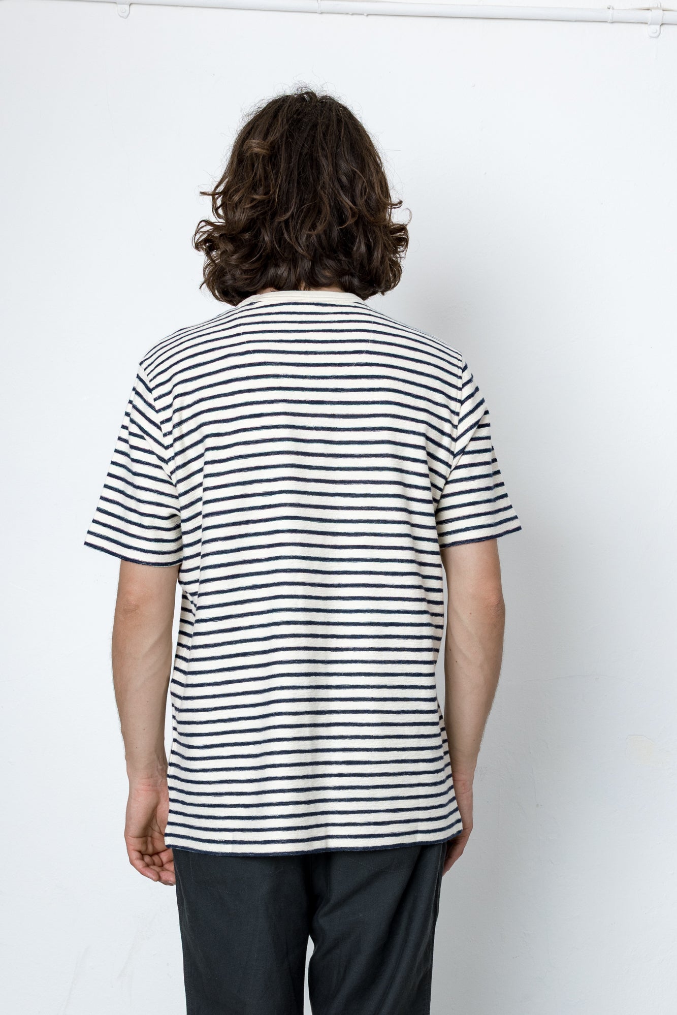 Person wearing a black and white striped shirt against a white background