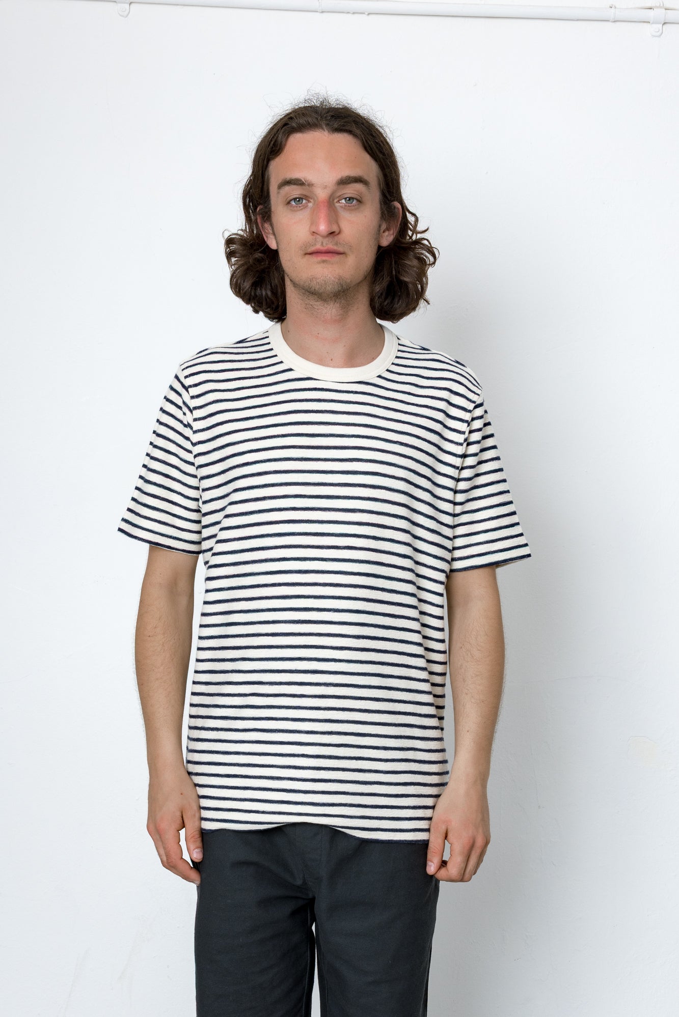 Person wearing a black and white striped t-shirt against a plain background