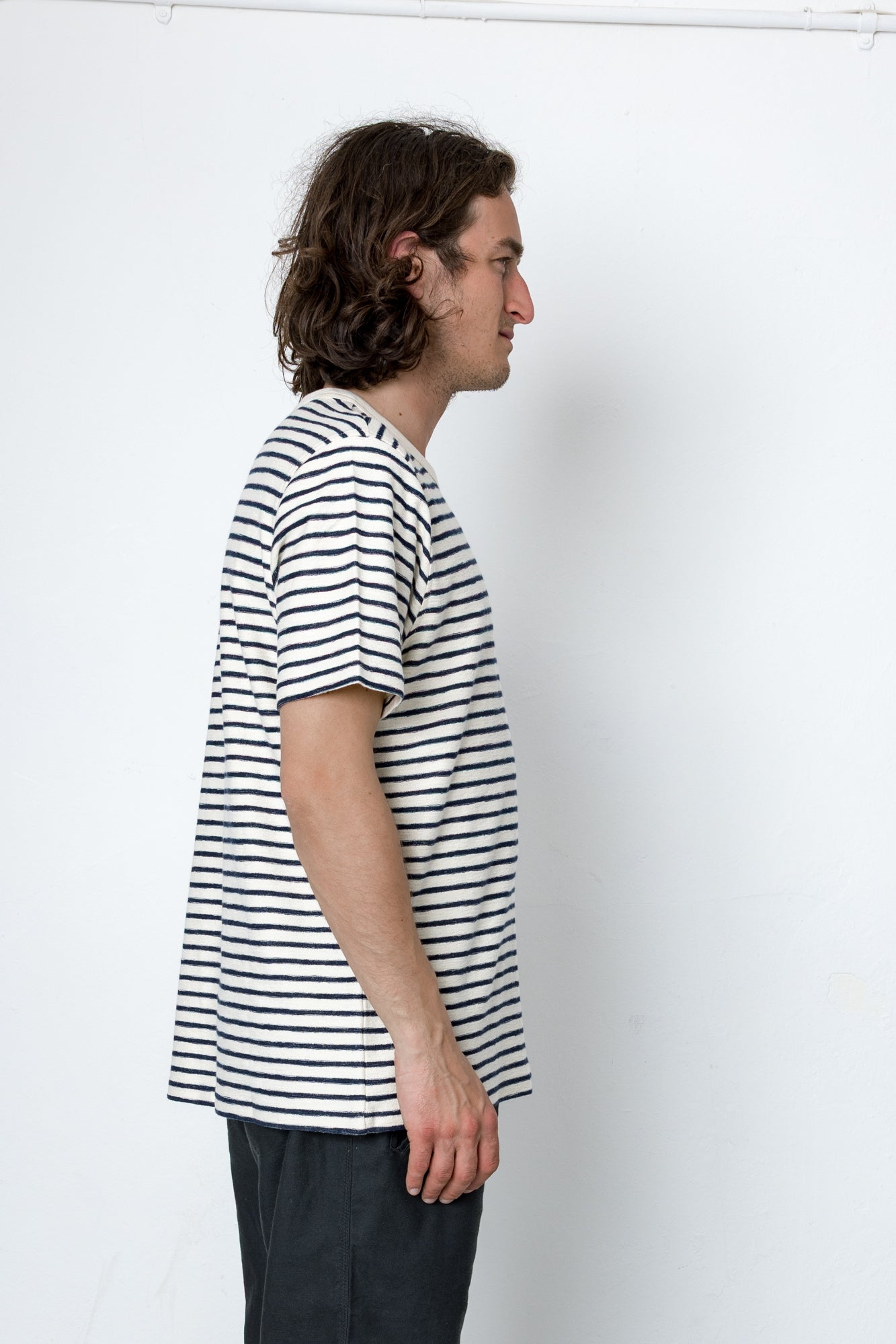Man wearing a black and white striped t-shirt against a white background